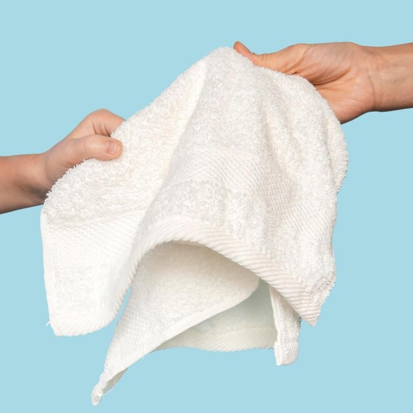 Cotton Hand Towel Being Stretched By Two Hands with Sky Blue Background.