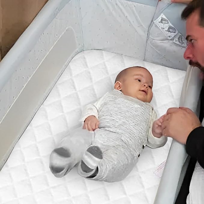 infant having fun with his father while laying on the chicco deluxe mattress