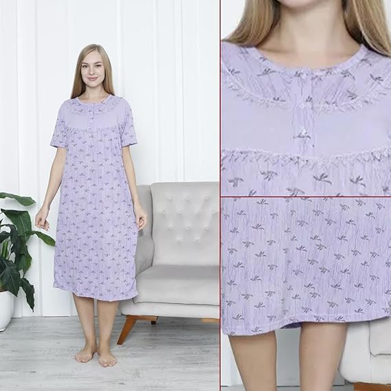 Woman wearing a purple floral nightgown in a room with a white wall and gray sofa.