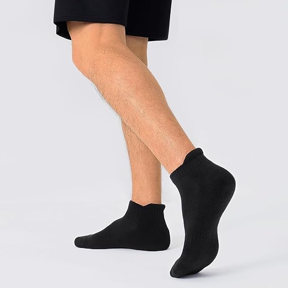 Person wearing black ankle socks on a plain background