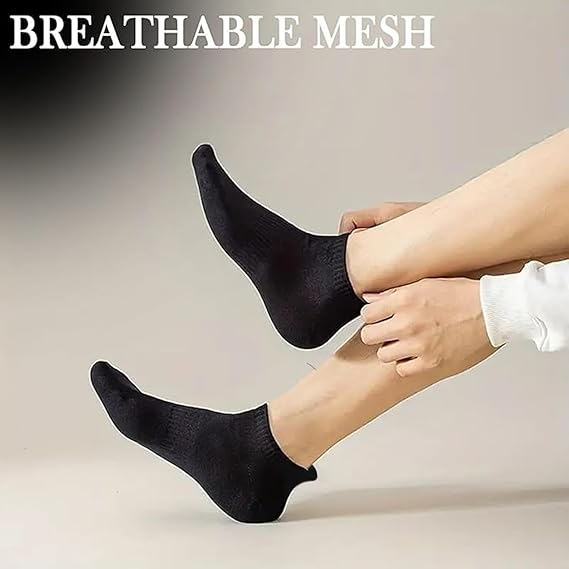 Person wearing black socks with 'BREATHABLE MESH' text on a neutral background