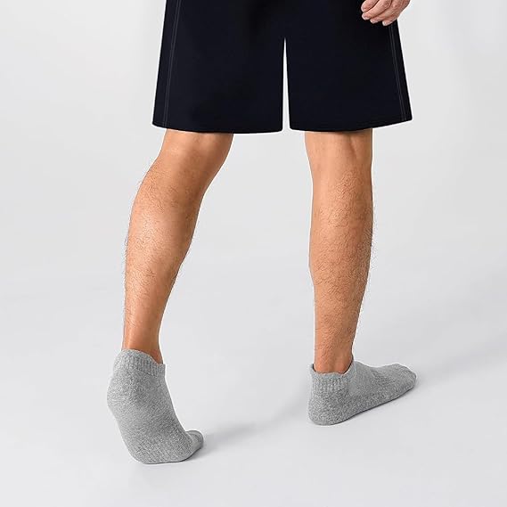 Person wearing black shorts and gray socks on a white background