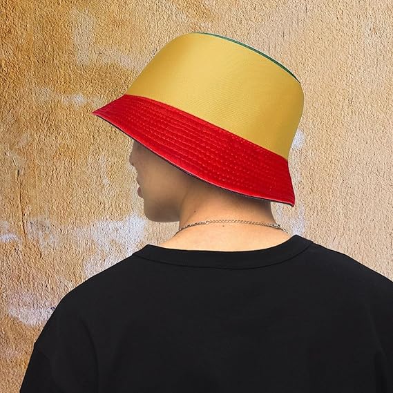 Person wearing a yellow and red bucket hat against a textured beige wall