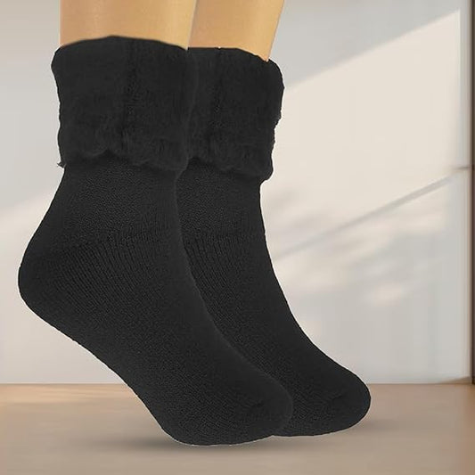 Black socks with fluffy cuffs on a neutral background