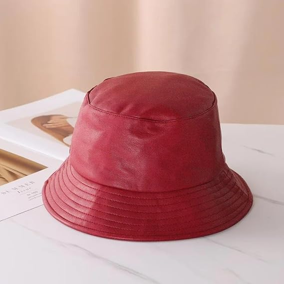 Red bucket hat on a light surface with a blurred background