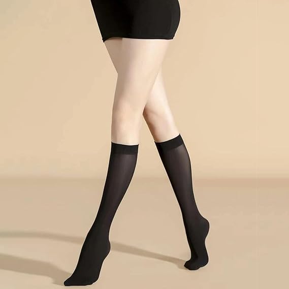 Black knee-high socks worn with a black dress on a beige background