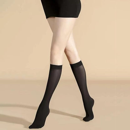 Black knee-high socks worn with a black dress on a beige background