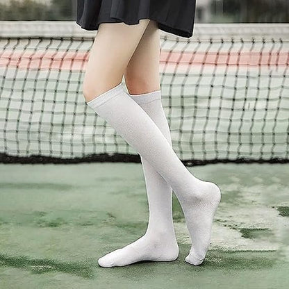 Person wearing white knee-high socks on a tennis court