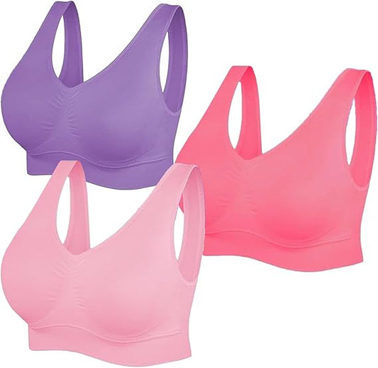 Three sports bras in purple, pink, and red on a white background